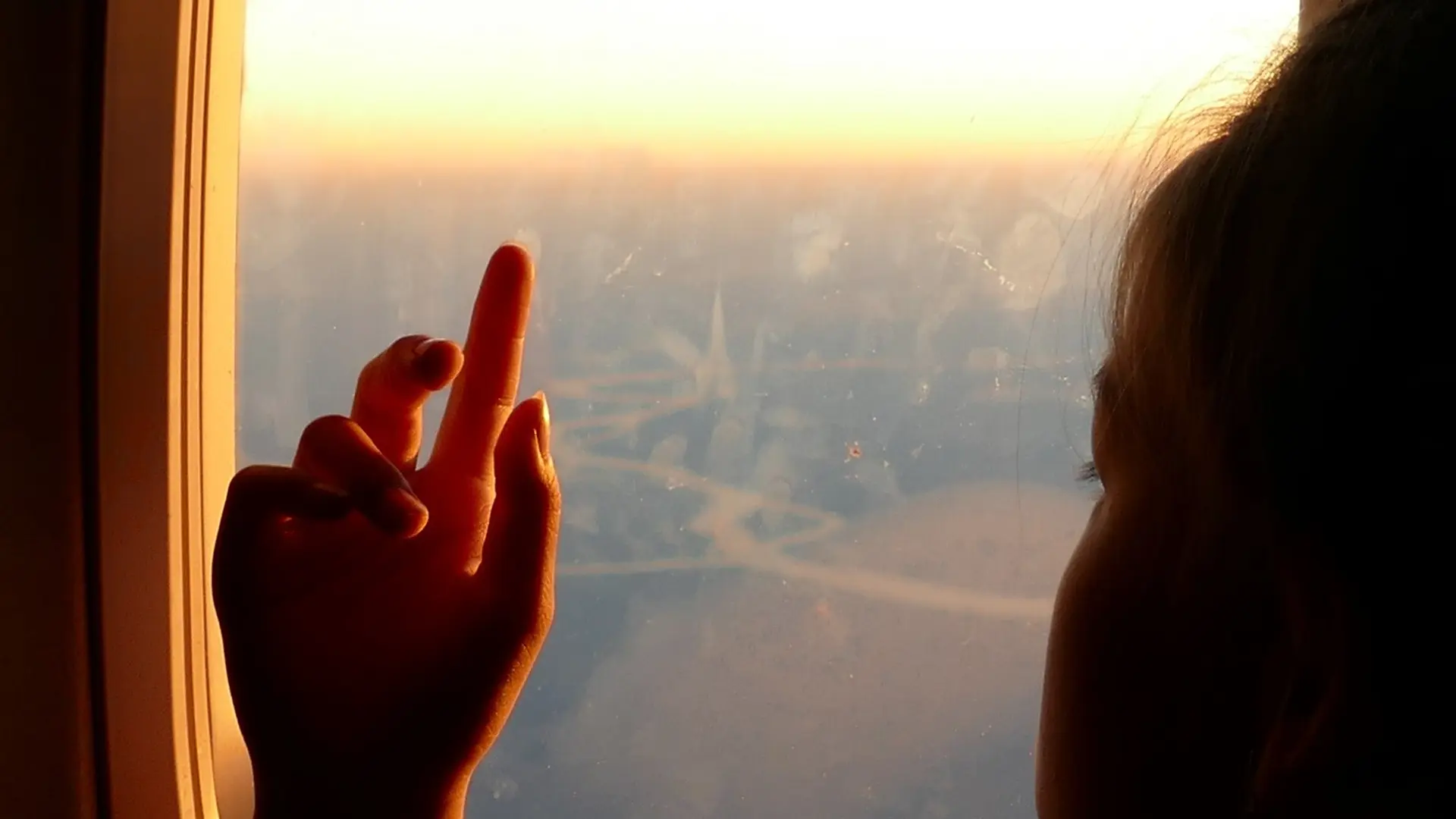 a young boy staring outside from an airplane