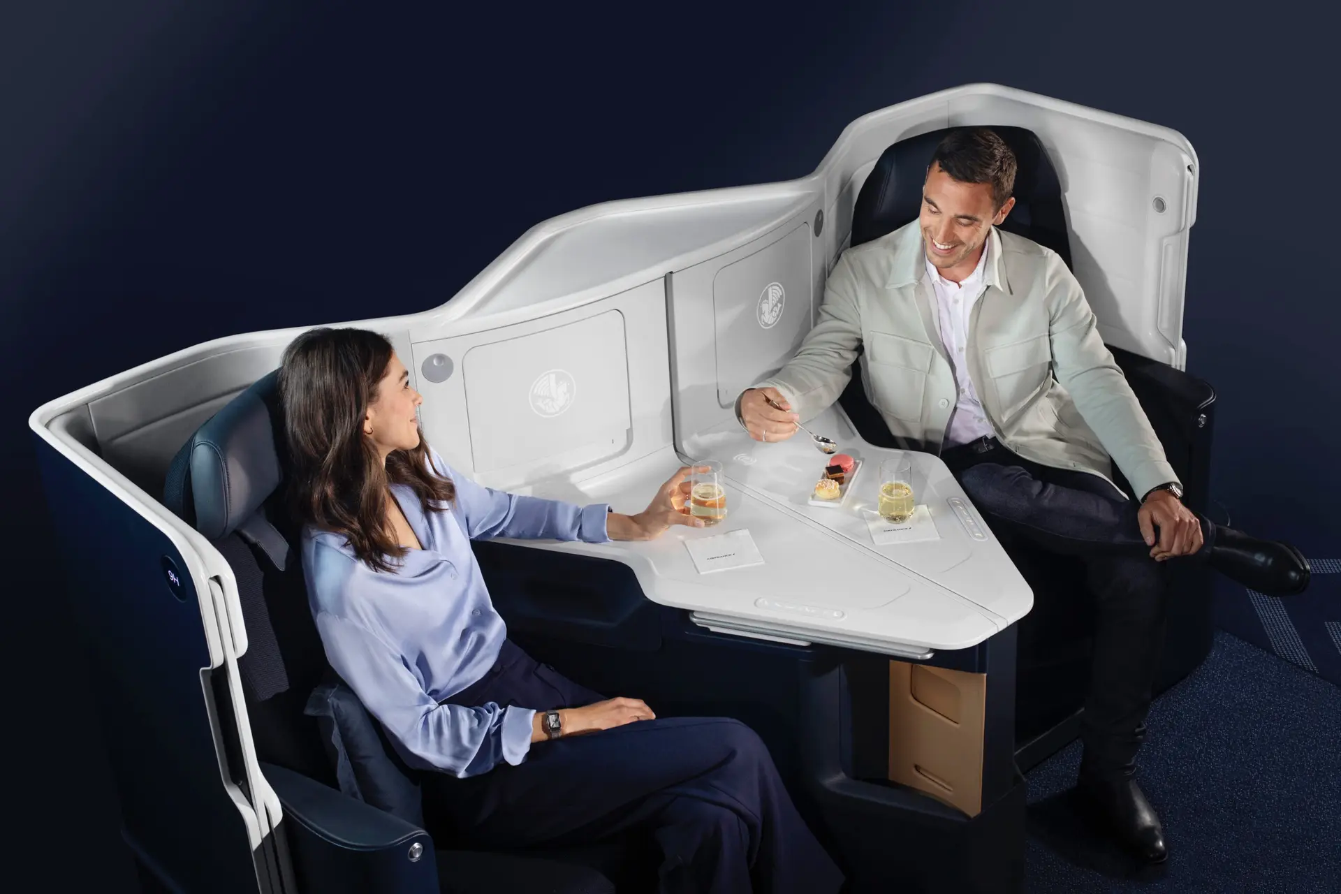 Couple enjoying champagne and cookies at a businessclass flight.